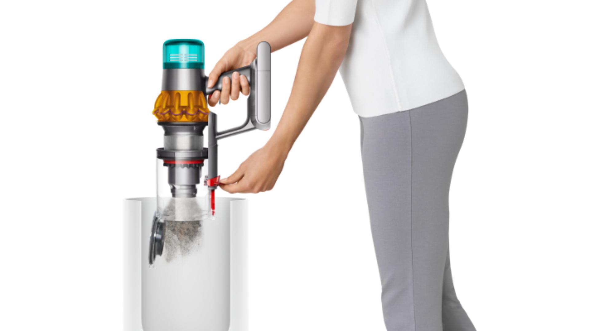 سيدة تقوم بتفريغ حاوية مكنسة Dyson Gen5detect بحركةٍ واحدةٍ.