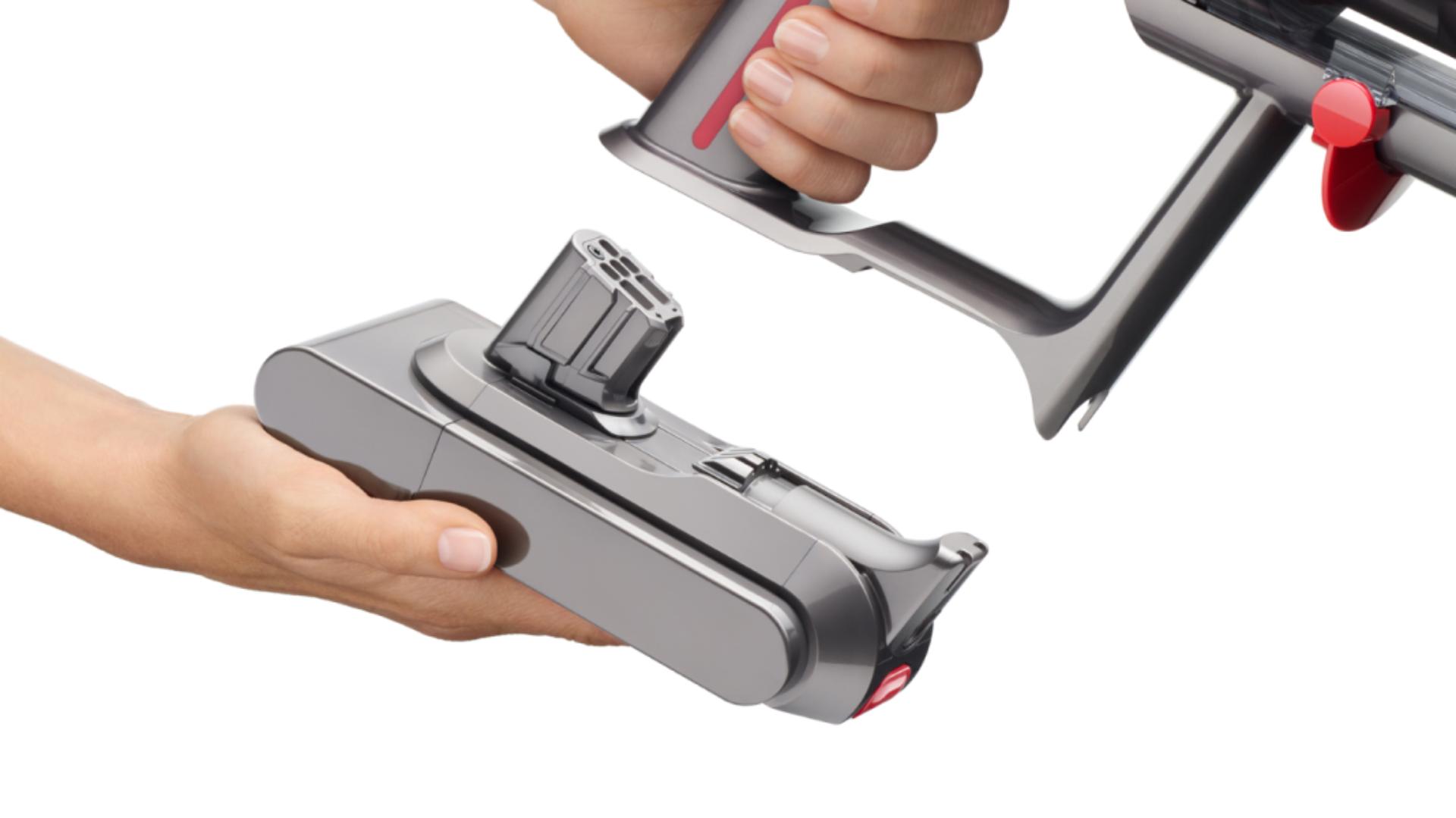 Close-up of a hand attaching a Click-in battery to the Dyson V15 Detect vacuum.