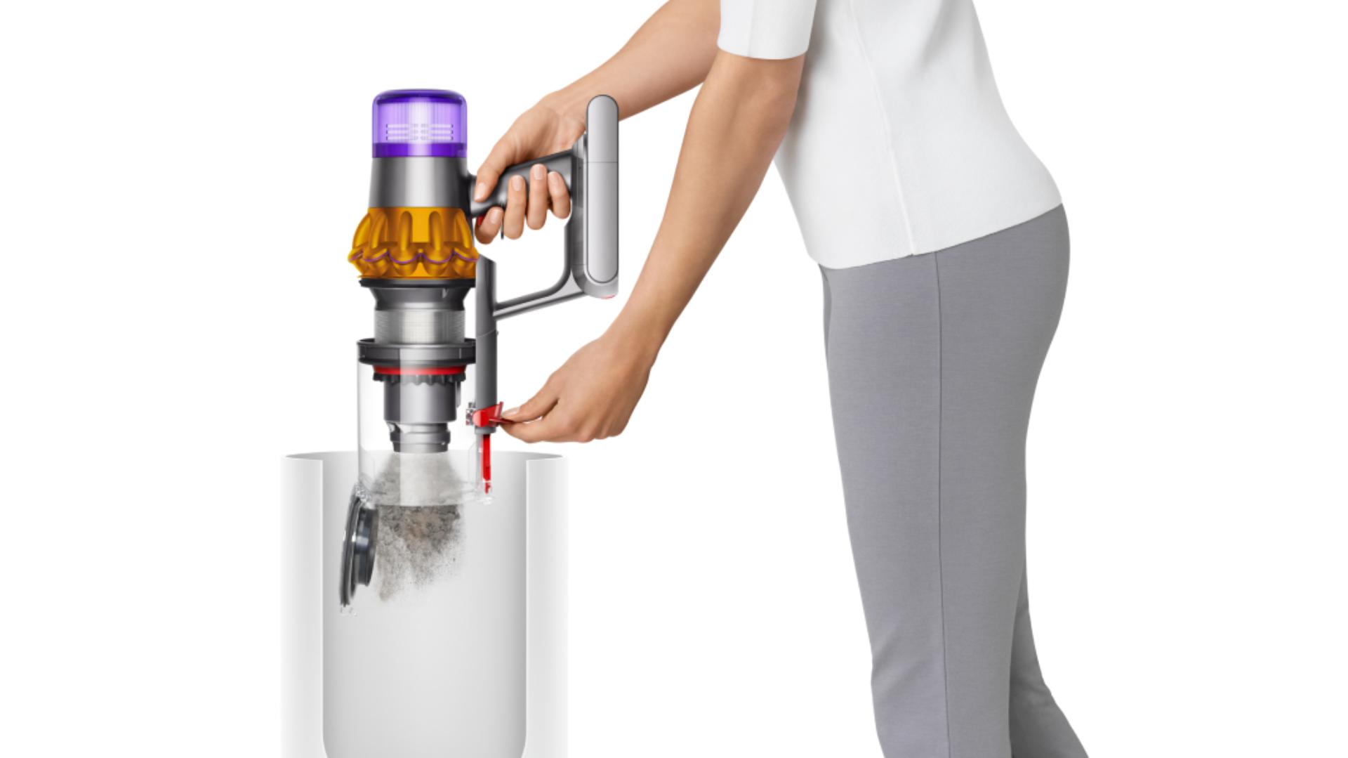 A woman emptying the bin of the Dyson V15 Detect vacuum.