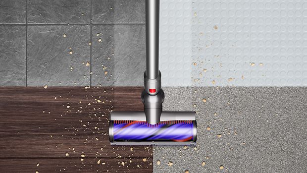 Overhead view of the Dyson V8 vacuum cleaning debris from hard floor and carpet.