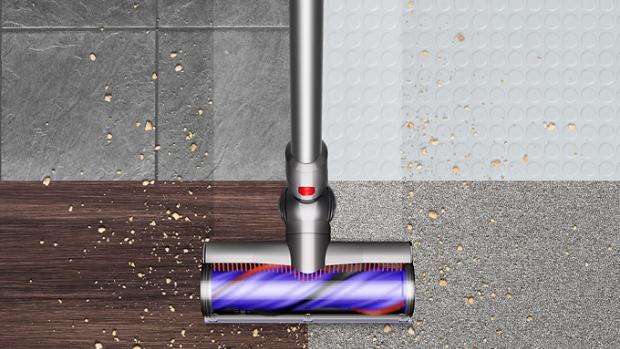 Overhead view of the Dyson V8 vacuum cleaning debris from hard floor and carpet.