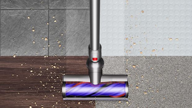 Overhead view of the Dyson V8 vacuum cleaning debris from hard floor and carpet.