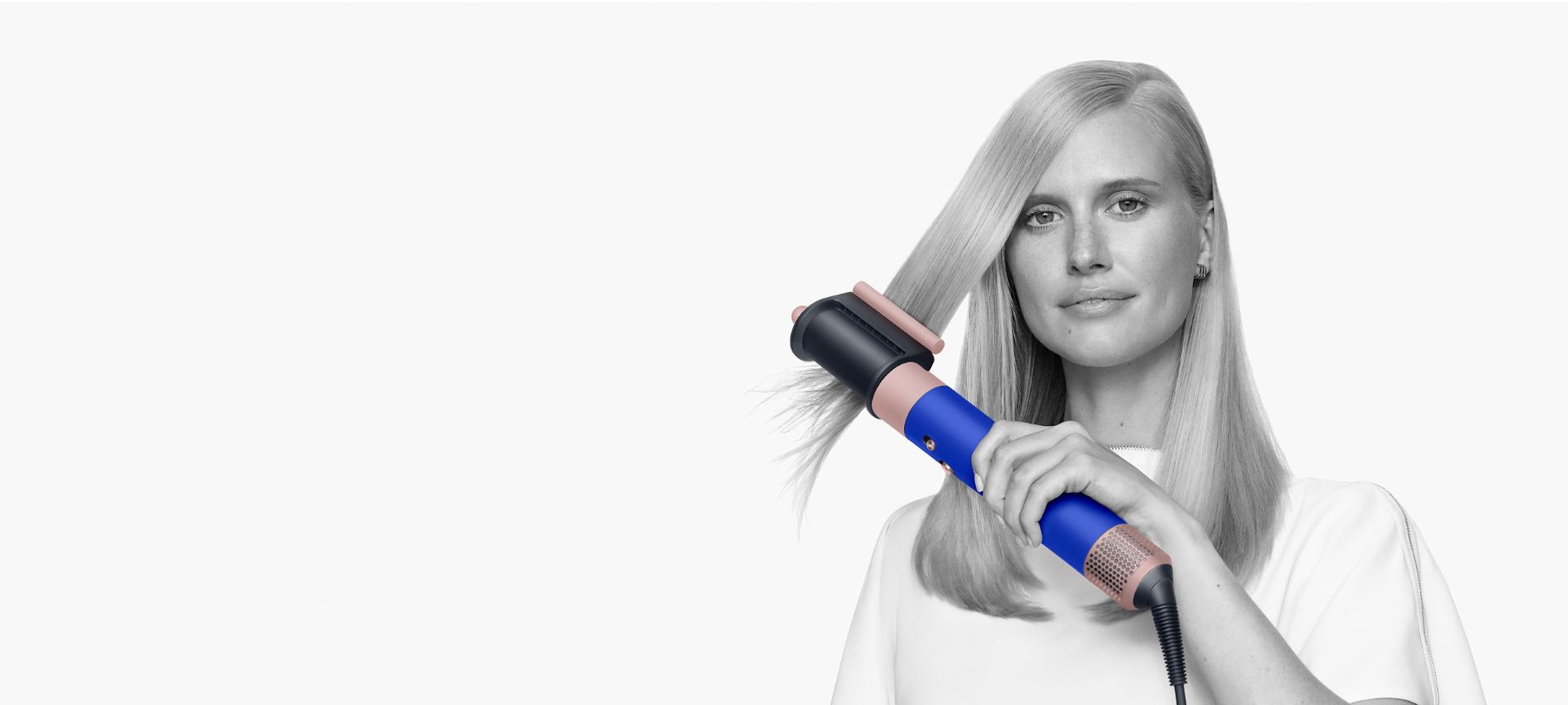 Model with type 1 hair using the Dyson coanda smoothing dryer blue blush