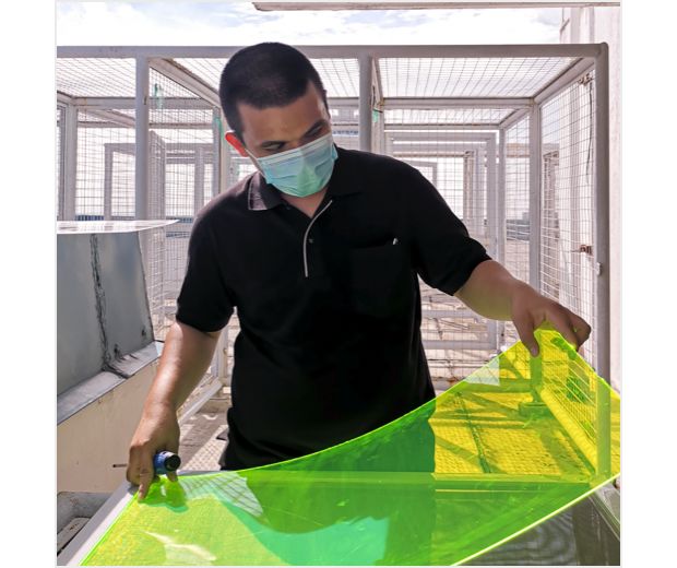 Čovjek drži obnovljenu, prozirnu zelenu ploču