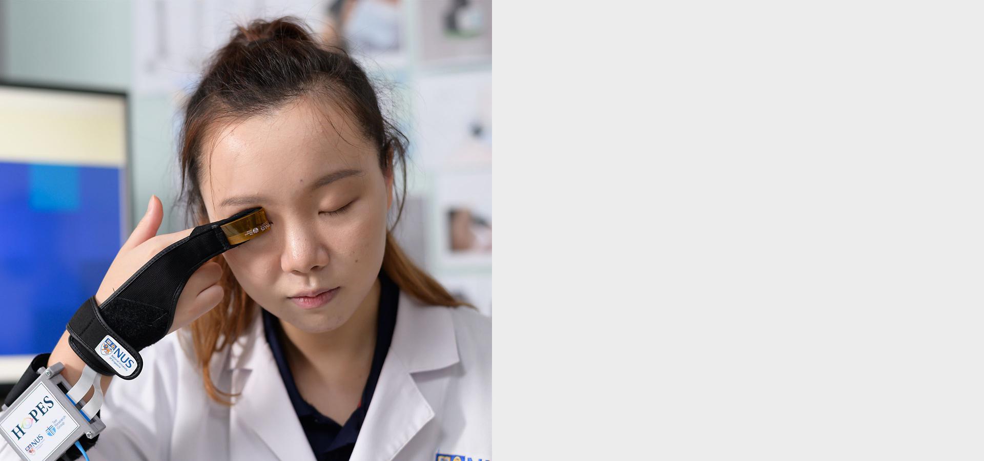 Žena sa zatvorenim očima drži uređaj za ispitivanje za podatke o glaukomu putem Bluetooth veze