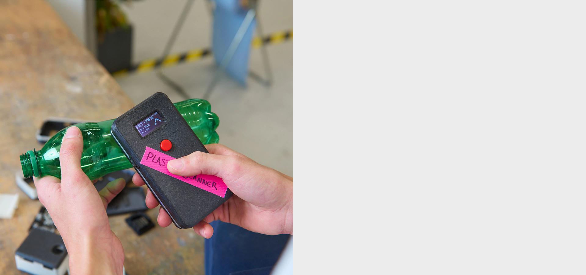 Kaks kätt kasutamas plastiskannerit rohelisel plastpudelil.