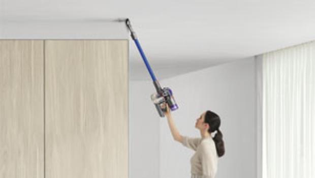 Woman cleaning up high with Dyson V8 vacuum