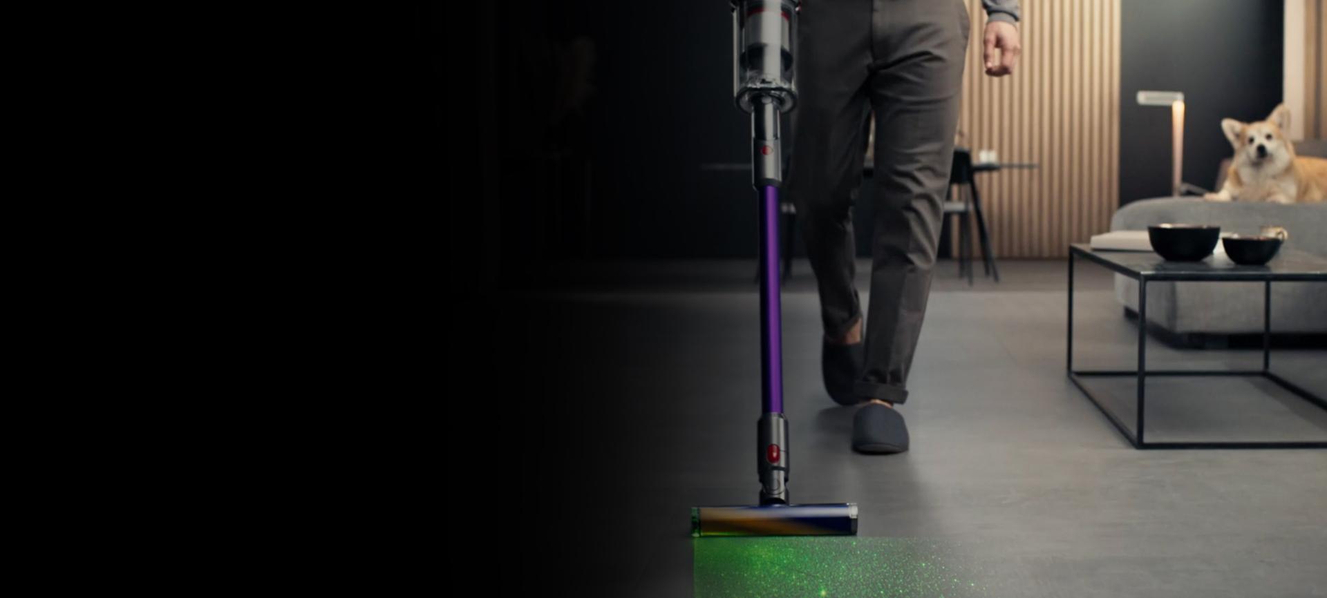 Women vacuuming with dog following