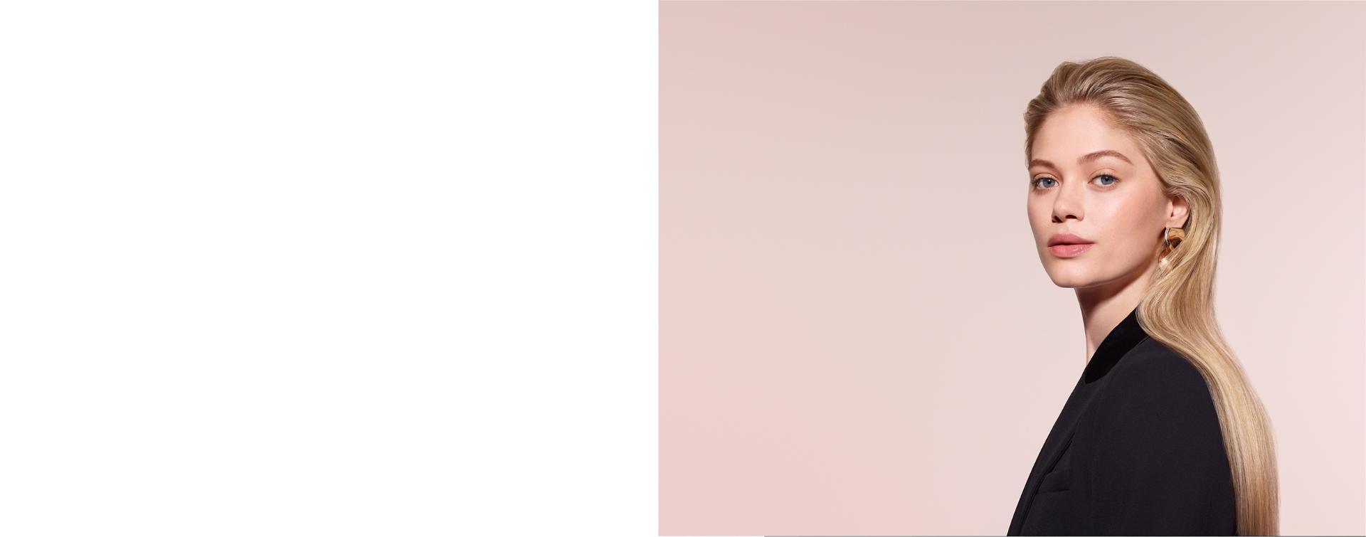 A model with blonde hair adds curls using the Dyson Airwrap Co-anda2x multi-styler and dryer.