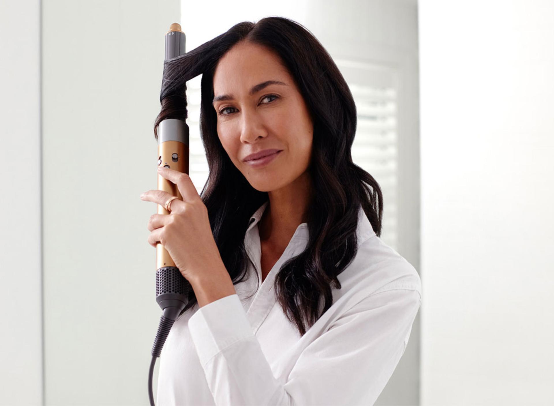 Two models using the Dyson Airwrap styler to curl hair 