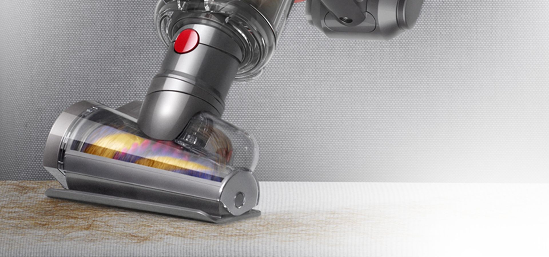 Dyson Micro with Hair screw tool removing hair from a fabric surface.