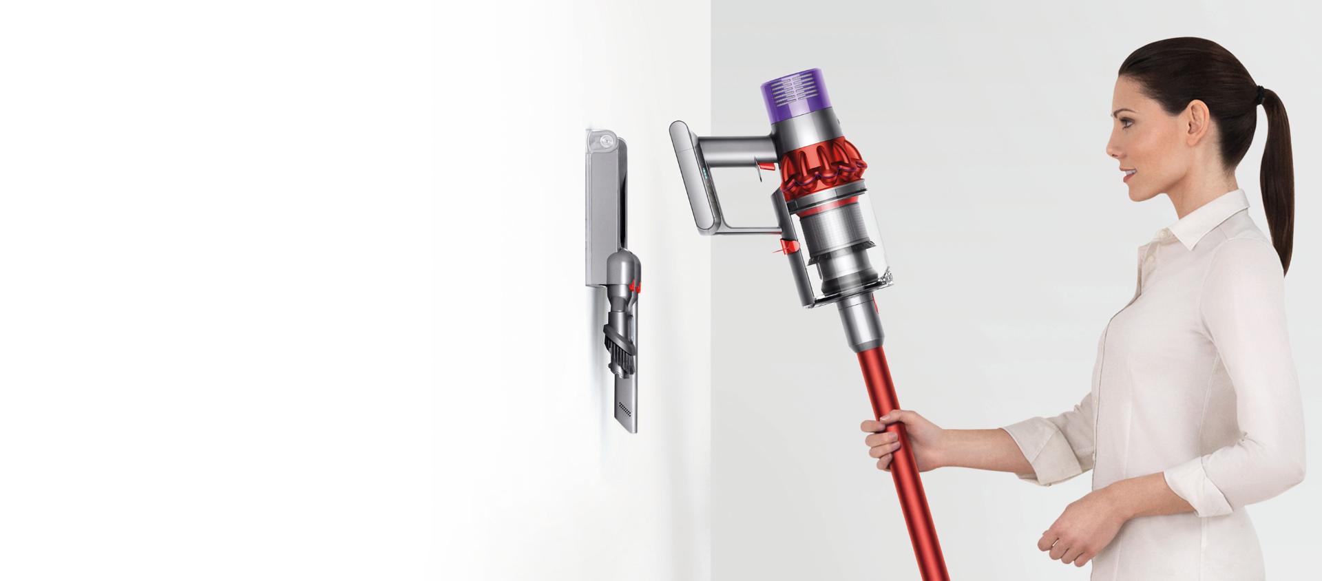 一位女士正在將Dyson Cyclone V10™ 吸塵機放入插入式充電底座