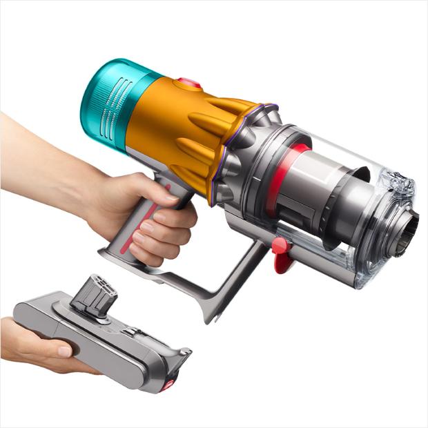 A hand is holding the V12s in one hand and the battery pack in the other hand.