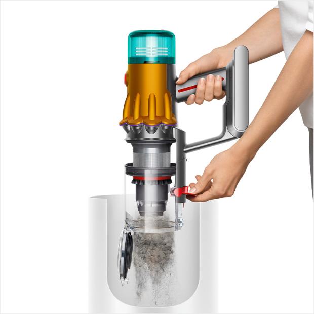 A person is emptying the bin of a V12s into the waste bin.