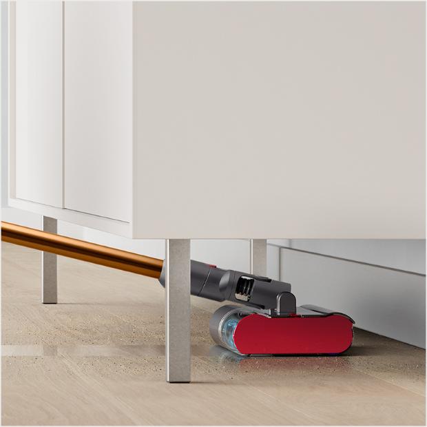 Fluffy Optic cleaner head reaching under a coffee table.