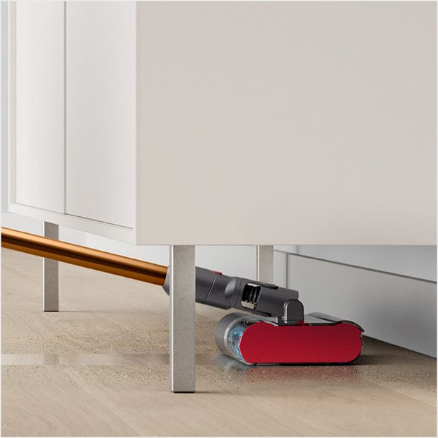 Fluffy Optic cleaner head reaching under a coffee table.