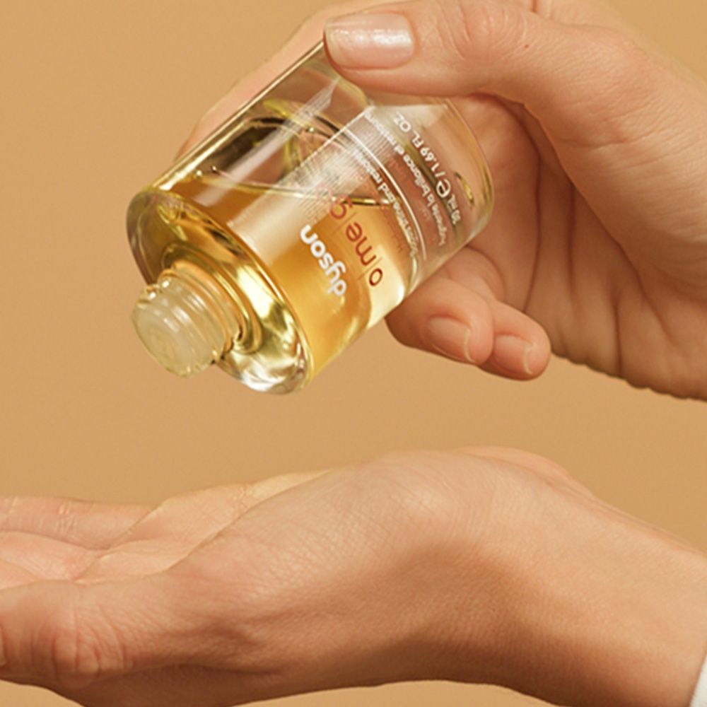 A blonde model shows off her smooth hair after using Dyson Omega products.