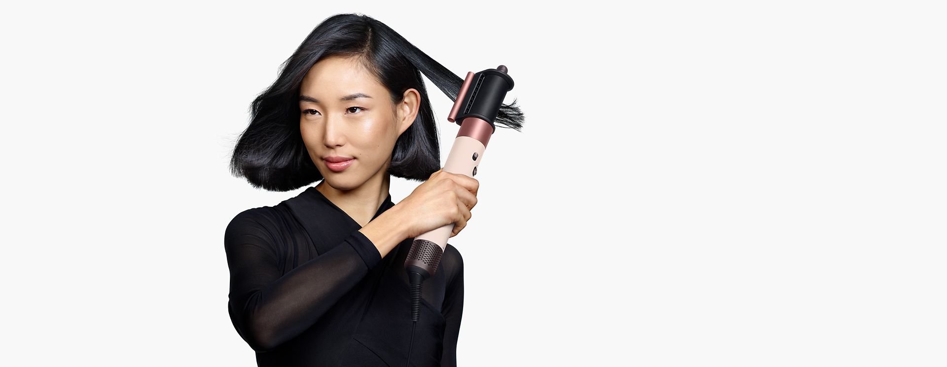 模特兒正在用 Dyson Airwrap i.d.™ 智能吹風造型器捲髮。