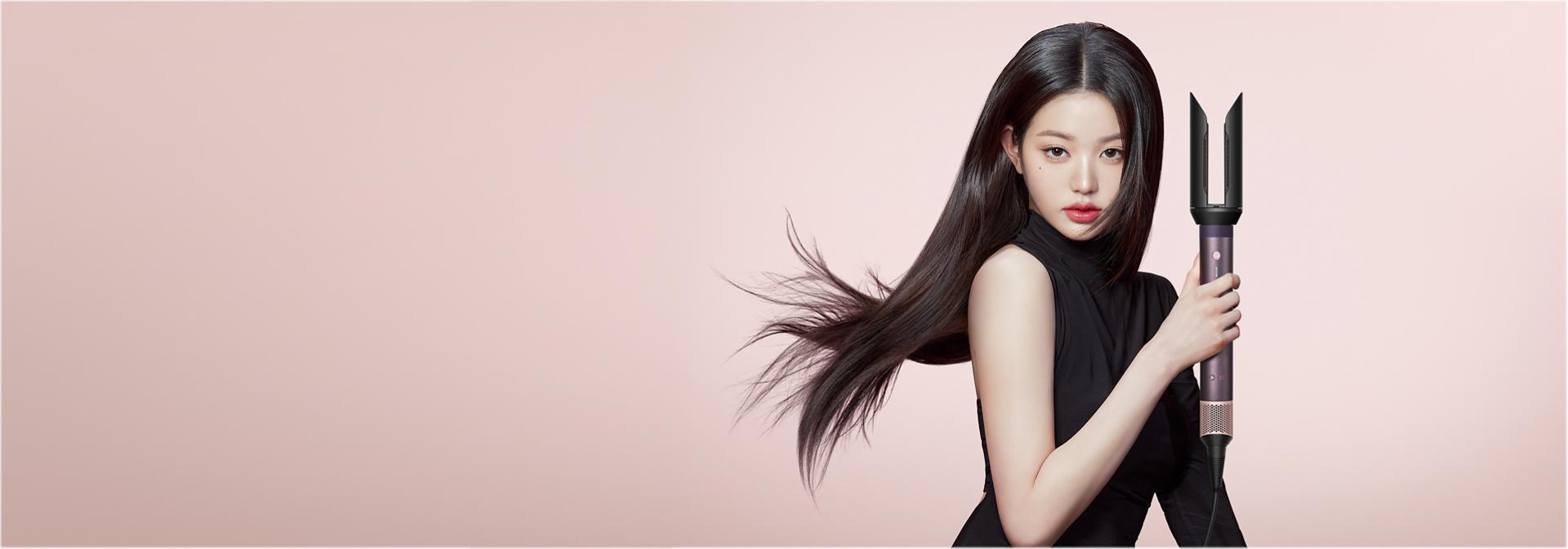 A model with blonde hair styled using the Dyson Airwrap Co-anda2x multi-styler and dryer with the Airsmooth2x attachment.