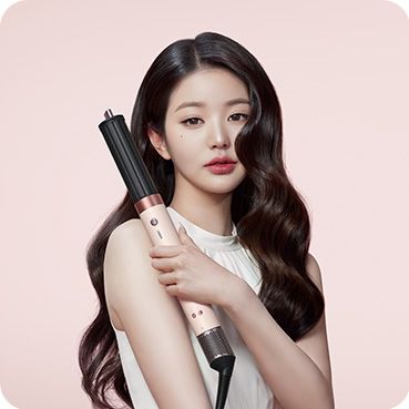 A model with dark hair adds curls using the Dyson Airwrap Co-anda2x multi-styler and dryer.