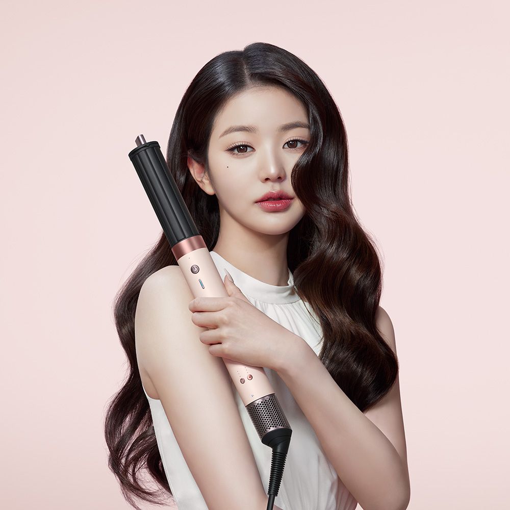 A model uses the Dyson Airwrap ID multi-styler and dryer to curl her hair.