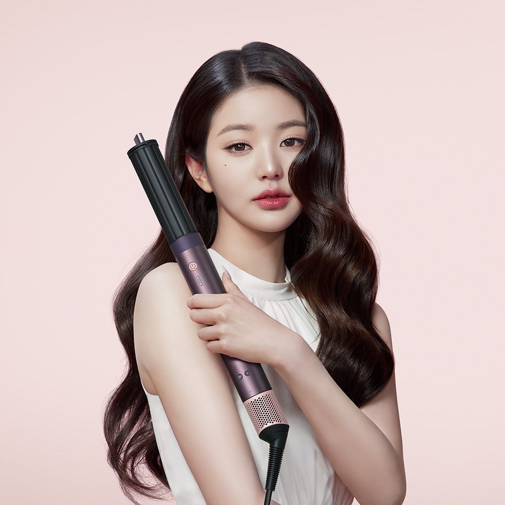 A model uses the Dyson Airwrap ID multi-styler and dryer to curl her hair.