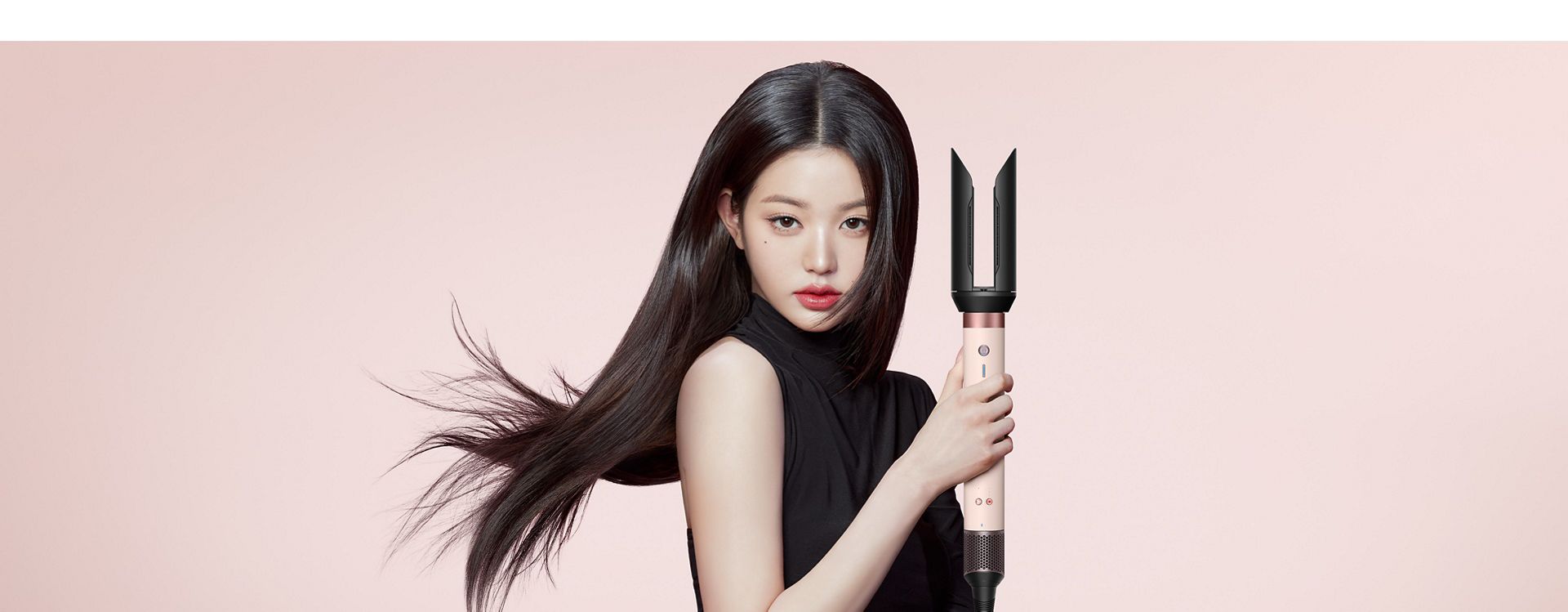 The Dyson Airwrap Co-anda2x multi-styler and dryer with the Airsmooth2x attachment used by a model with blonde hair.