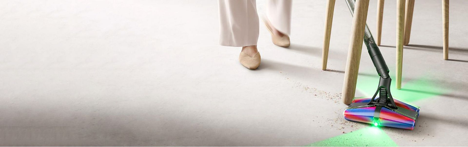 The Dyson PencilVac Fluffycones cleaner cleans around the legs of a chair.