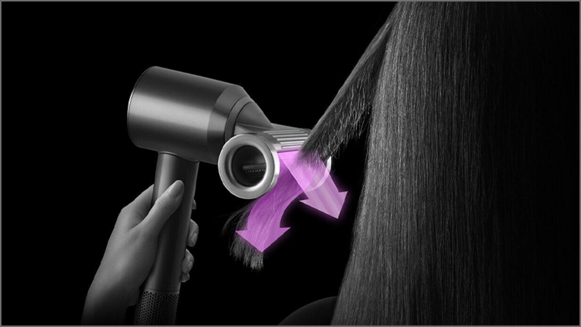 A tress of hair is styled using the Dyson Supersonic with Flyaway smoother attachment in Flyaway mode.