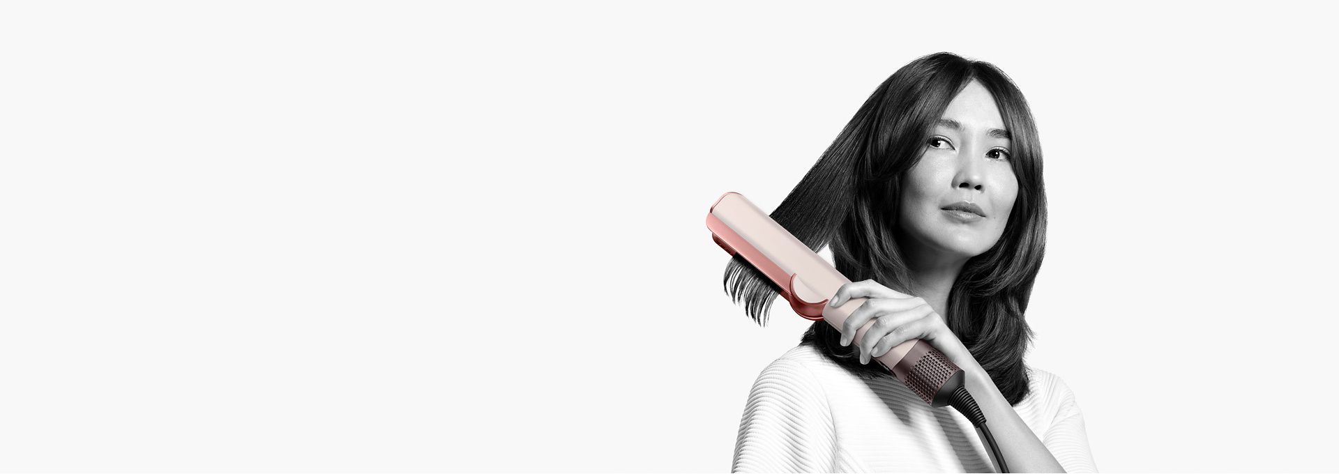 A woman using Dyson Airstrait