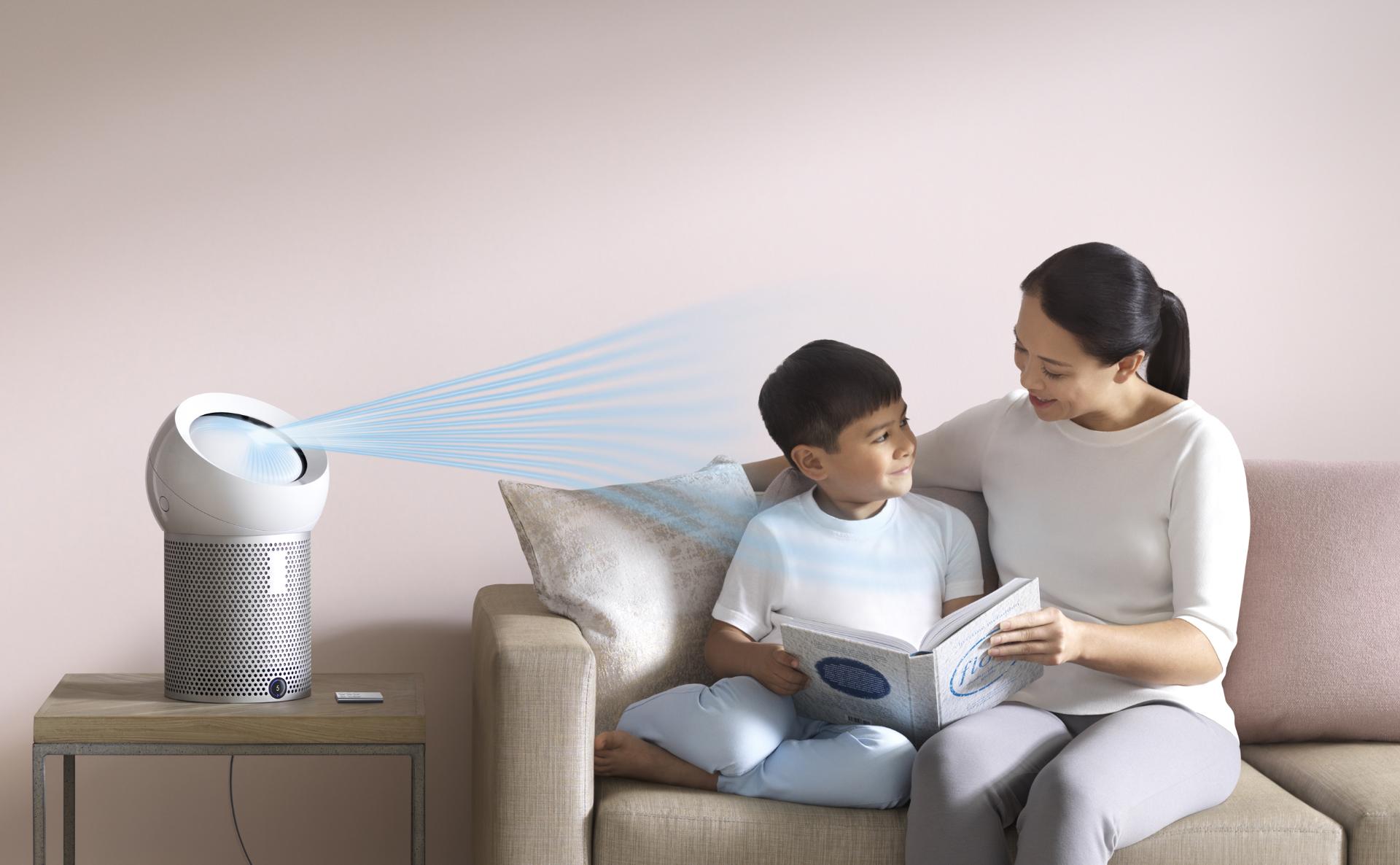 Una mujer leyendo a su hijo, junto a un ventilador Purificador Personal Dyson