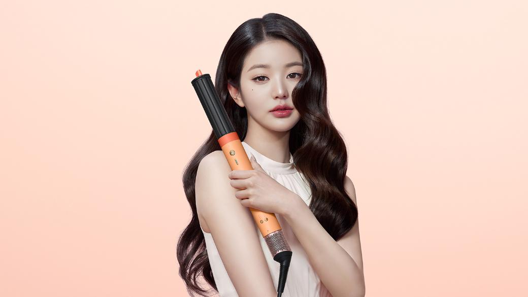 Model with curly hair using the Dyson Airwrap Co-anda2x multi-styler and dryer.