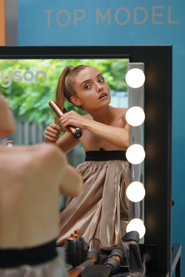 Modelka z Top Model stylizująca włosy prostownico-lokówką Dyson Corrale