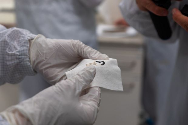 pracownik laboratorium trzymający inteligentny opatrunek SmartHEAL