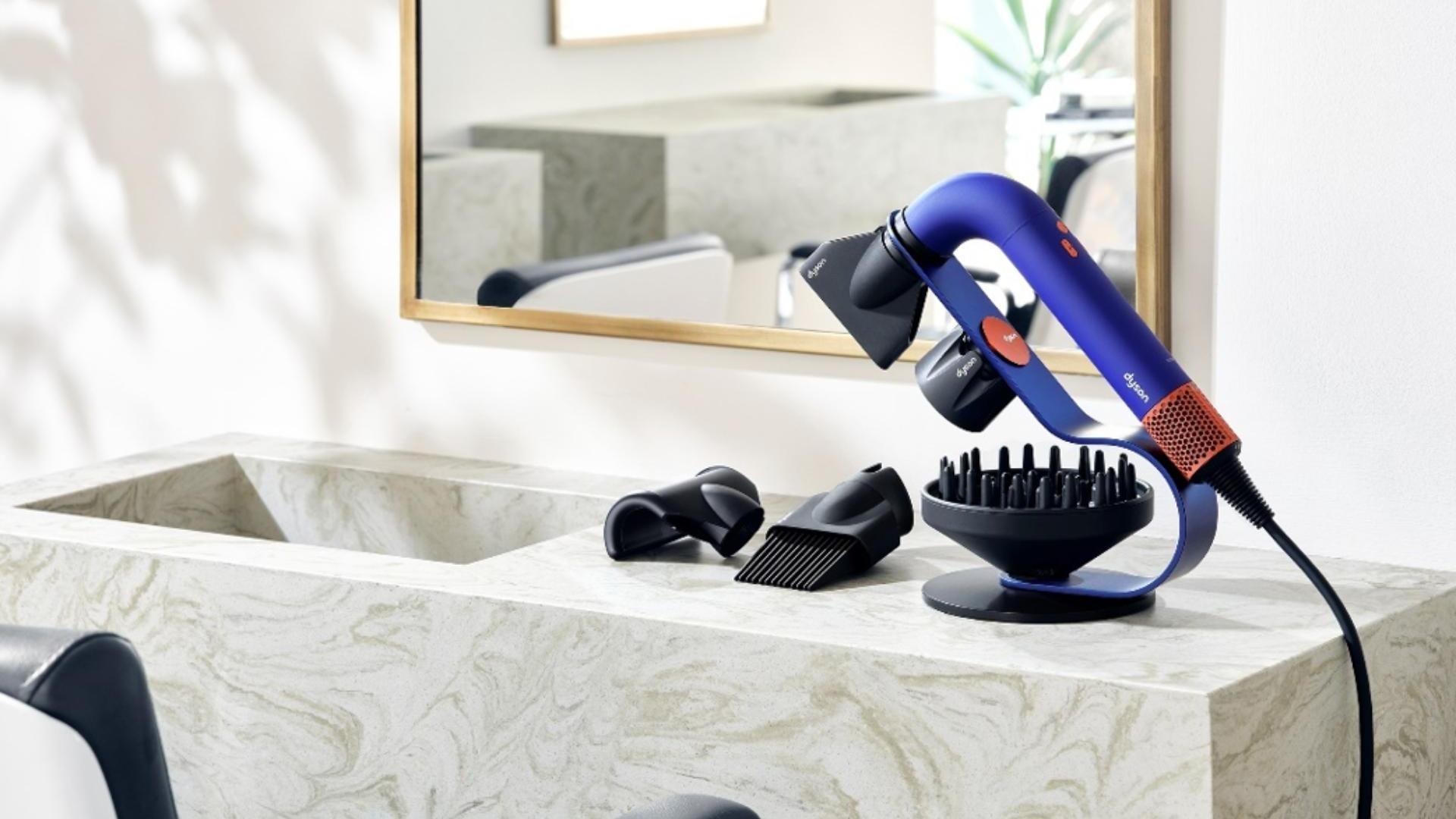 Suszarka do włosów Dyson Supersonic r Professional leżąca na stojaku przy lustrze salonu fryzjerskiego