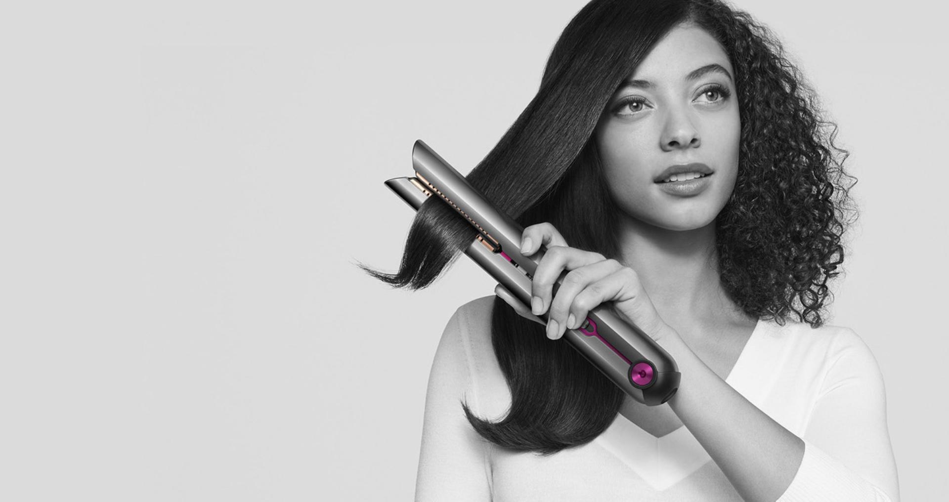 Woman achieving beautifully straight hair with the Dyson Corrale™ straightener