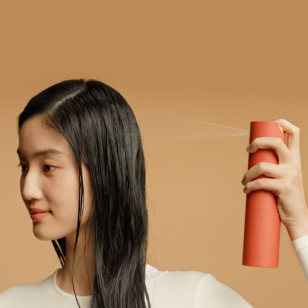 A straight hair model shows off her smooth hair after using Dyson Omega products.