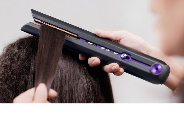 Professional stylist using the Dyson Corrale hair straightener