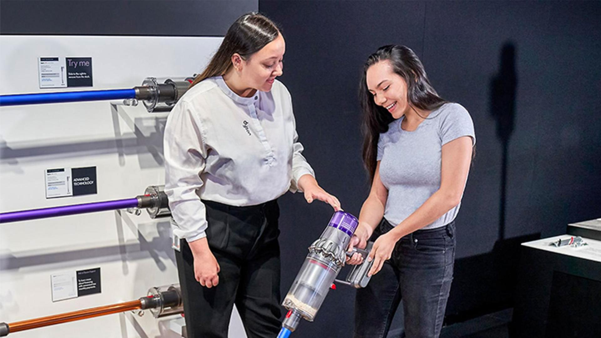 Dyson Expert talking to a customer in front of two Dyson purifiers
