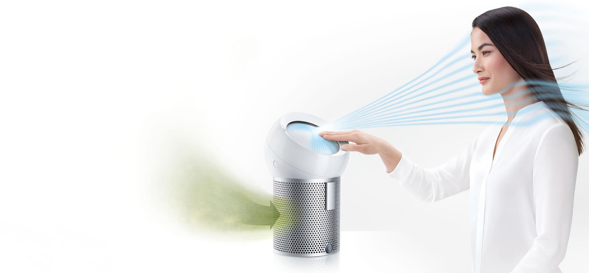 A woman using the Dyson Pure Cool Me personal purifier fan to project cooling, purified air
