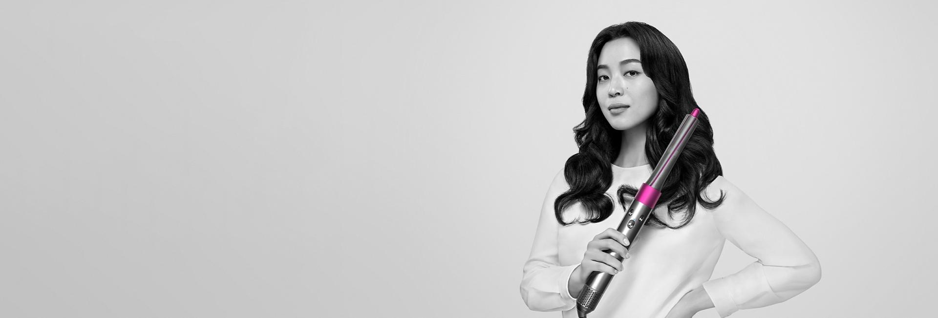 Woman curls her hair with Dyson Airwrap styler.