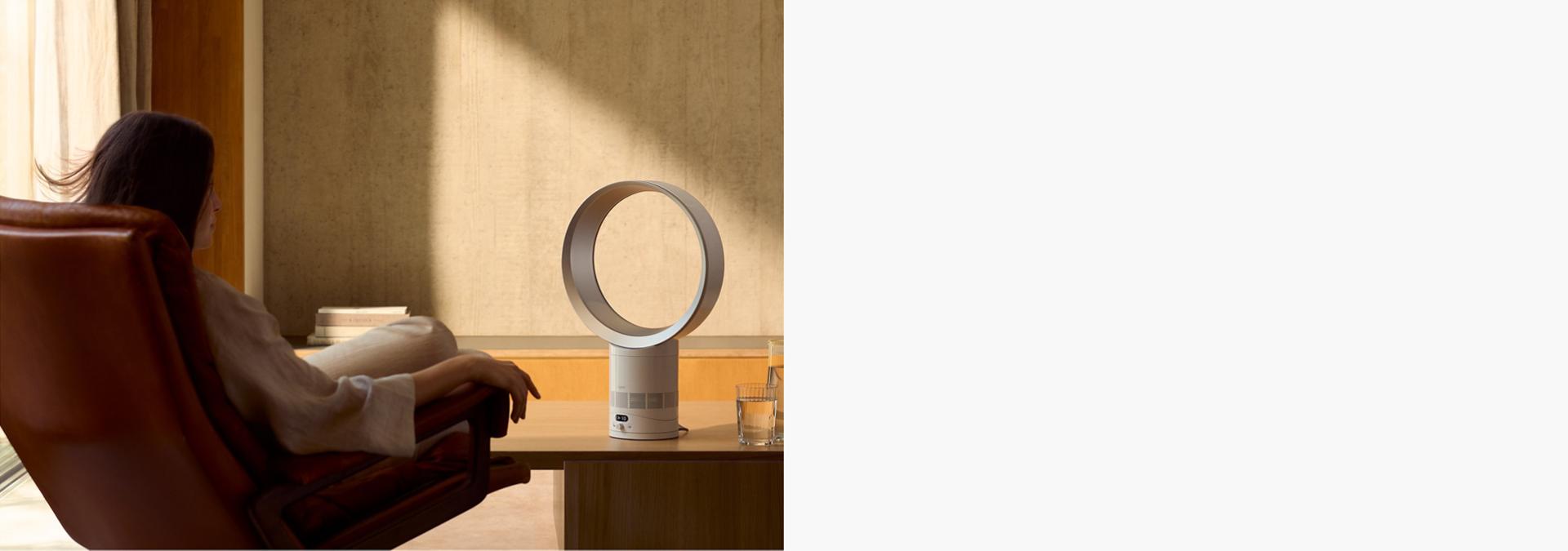 The Dyson Cool CF1 delivering a cool breeze to a person relaxing in a chair.