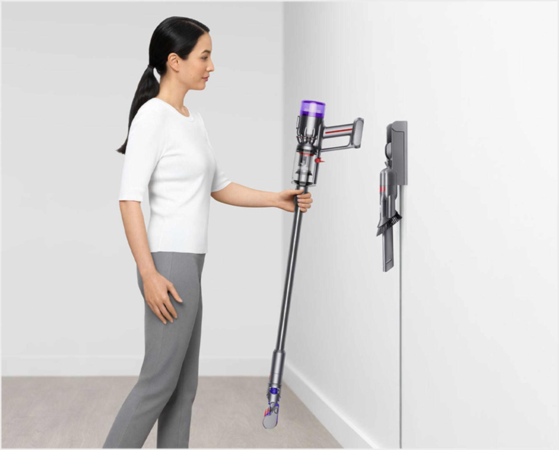 Woman dropping the Dyson Micro vacuum into the wall dock