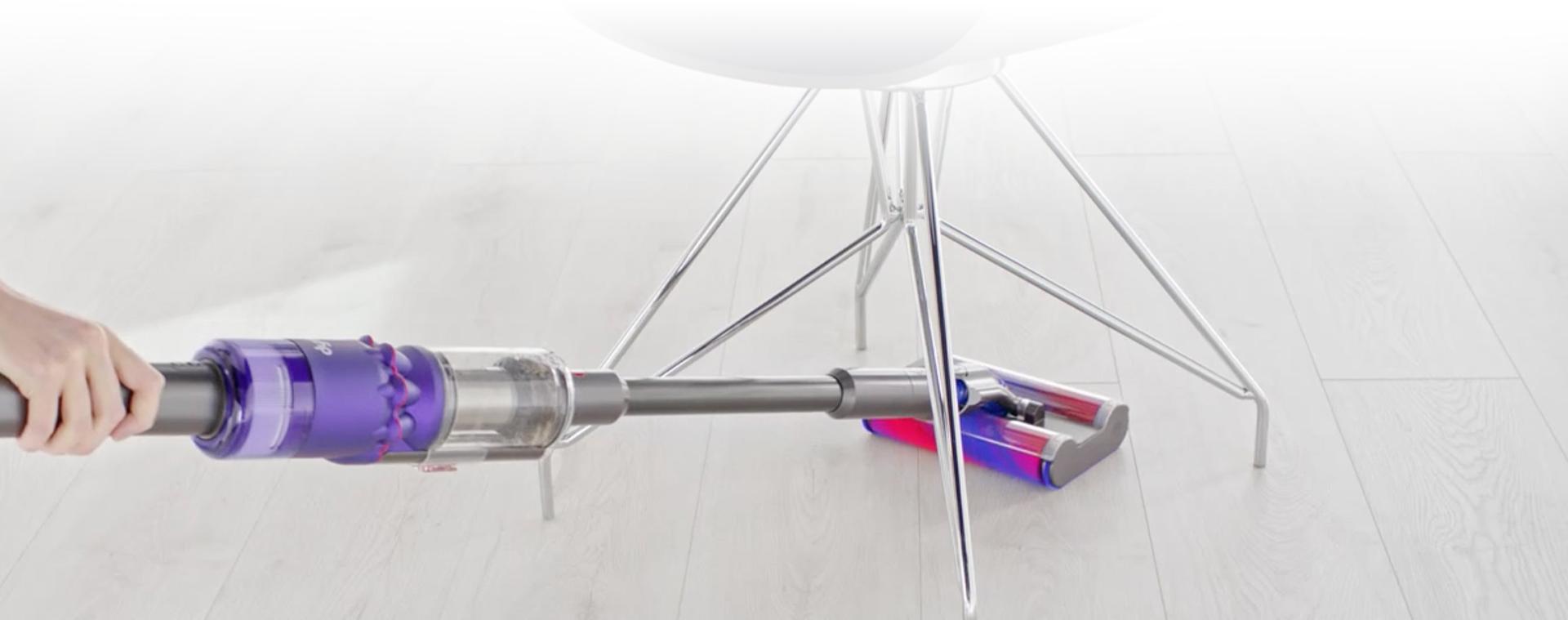 Video penyedot debu Dyson Omni-glide™ bermanuver di sekitar kaki meja.