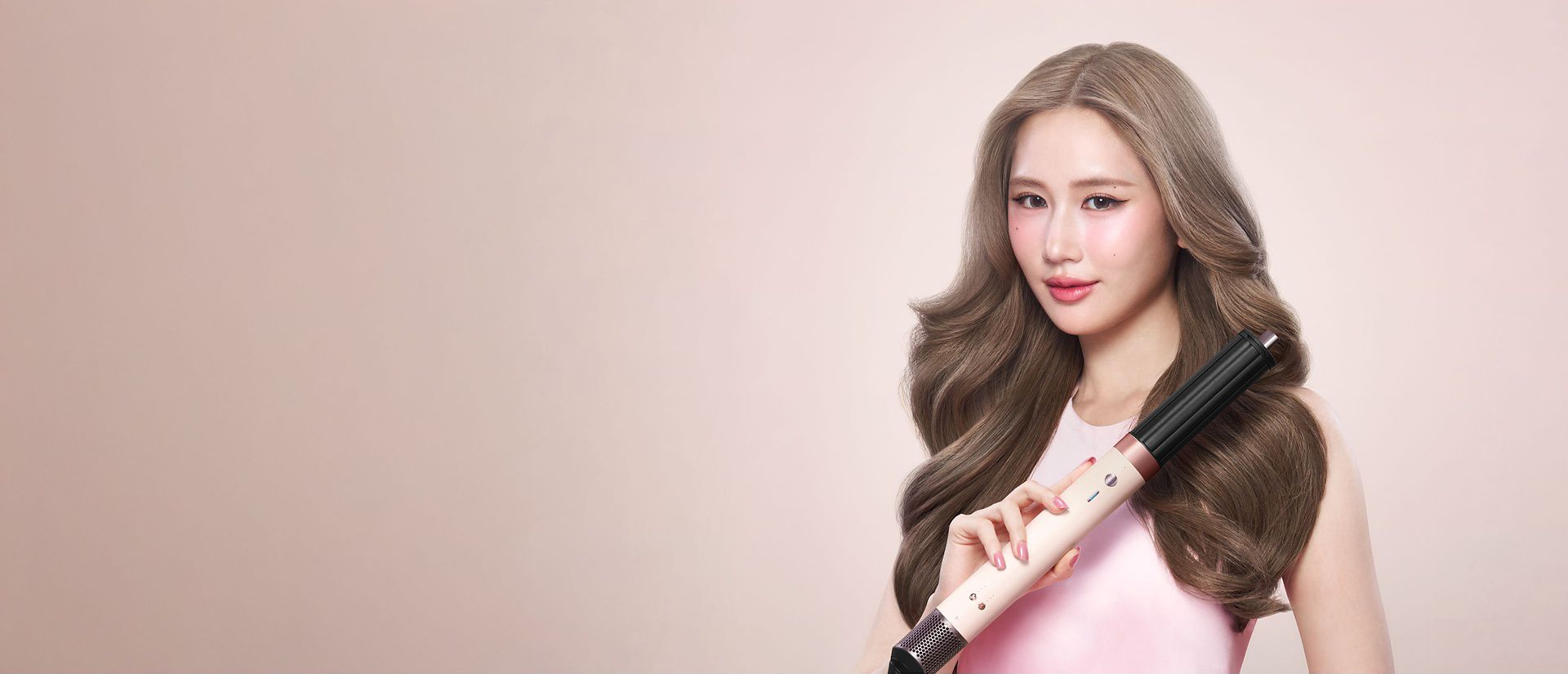 Splitscreen of the Dyson Airwrap Co-anda2x multi-styler and dryer, and a model with hair styled with the device.