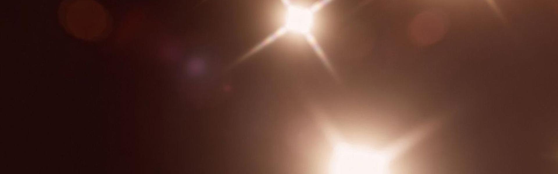 Karanlık bir arka plan üzerinde parlayan ışıklar.