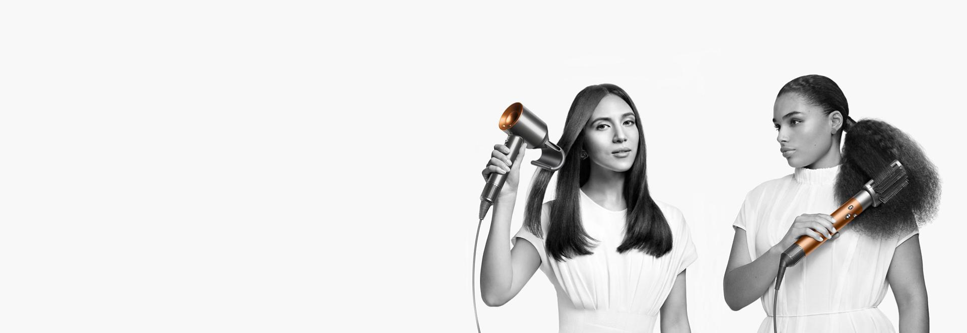 Two women demonstrating Dyson hair care range