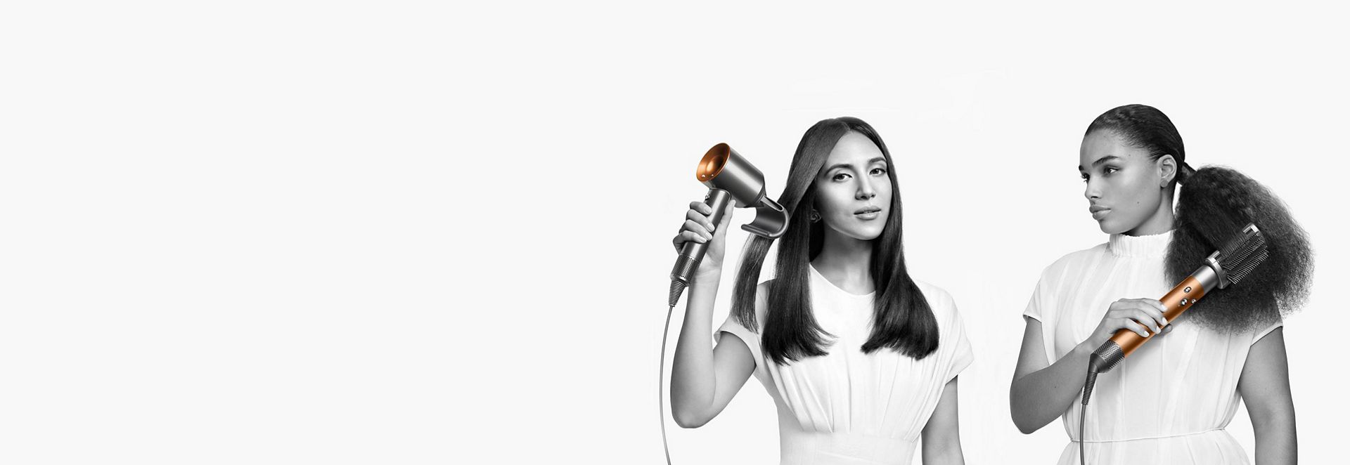 Two women demonstrating Dyson hair care range