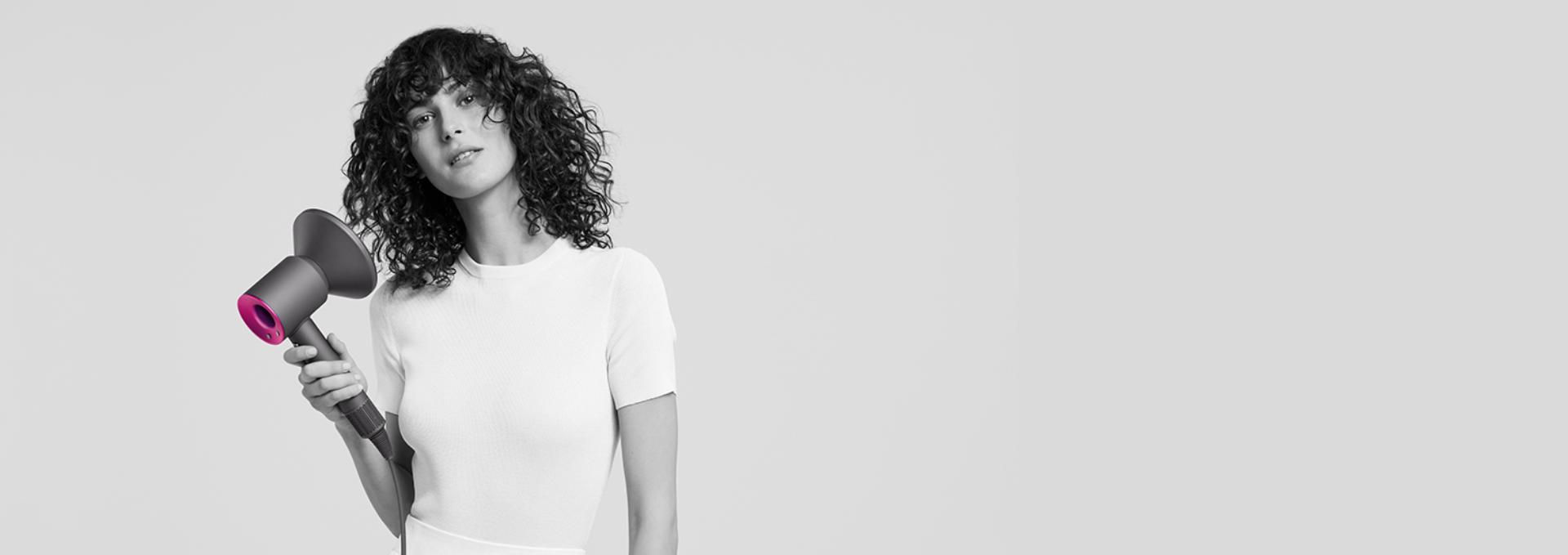 אישה משתמשת במייבש השיער Dyson Supersonic