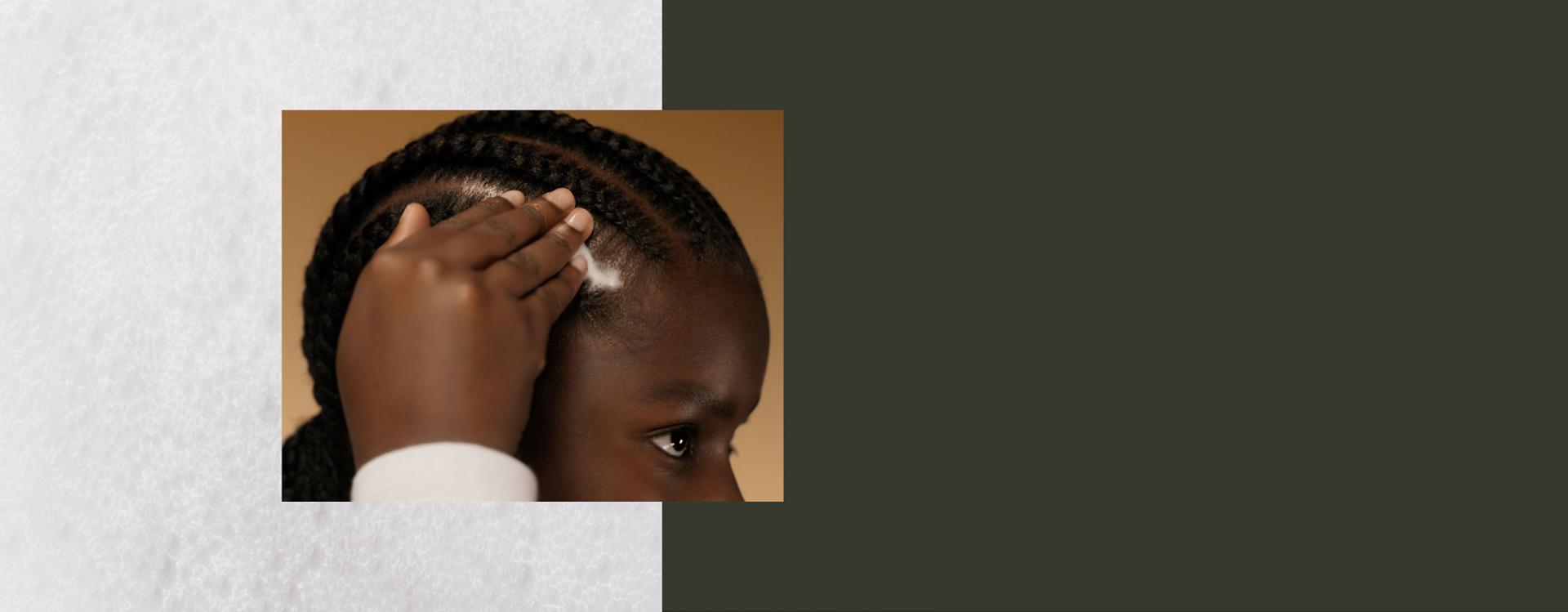 A model massages Dyson Amino leave-in scalp bubble treatment into her scalp.